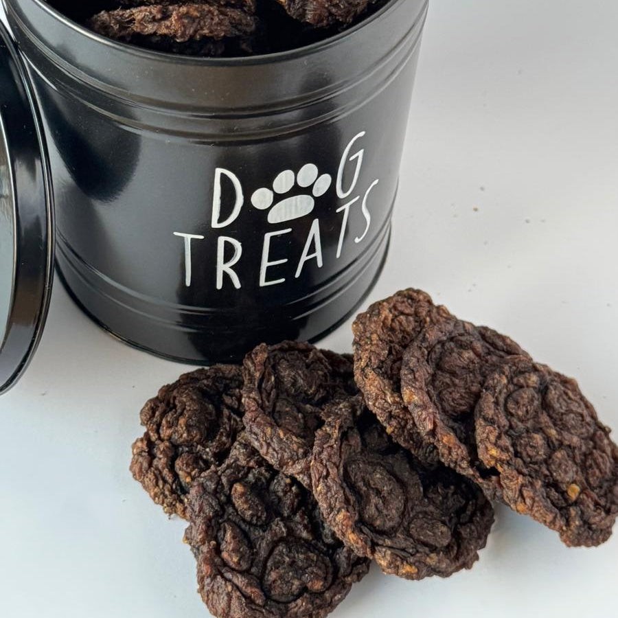 Beef & Blueberry Bites in a black dog treat tin, with more bites beside it