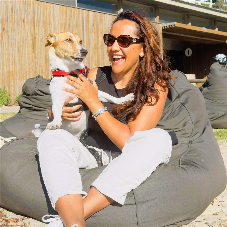Massy laughing with Pablo the Jack Russell in her arms at a Sydney beach